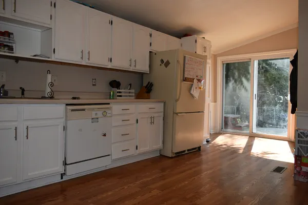 a kitchen with white cabinets and refrigerator
