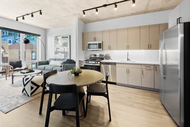 a kitchen with a table chairs refrigerator and cabinets