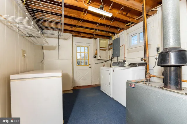 a view of a white house with a large trees