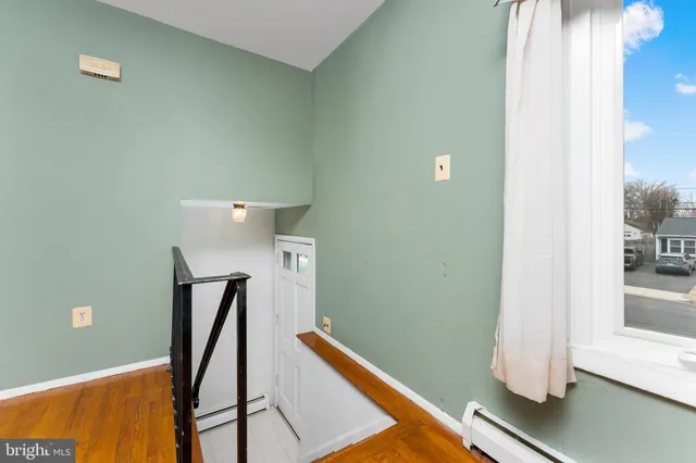 a view of a room with wooden floor and white walls