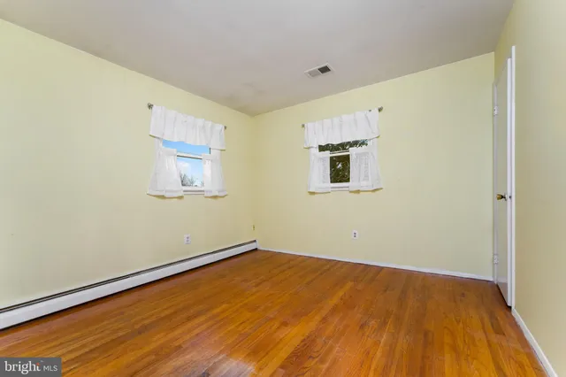 a view of a room with wooden floor and a window