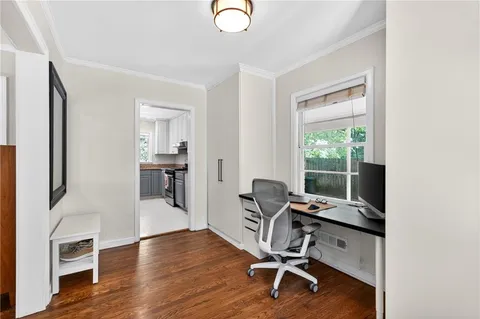 a view of a workspace with furniture and a window