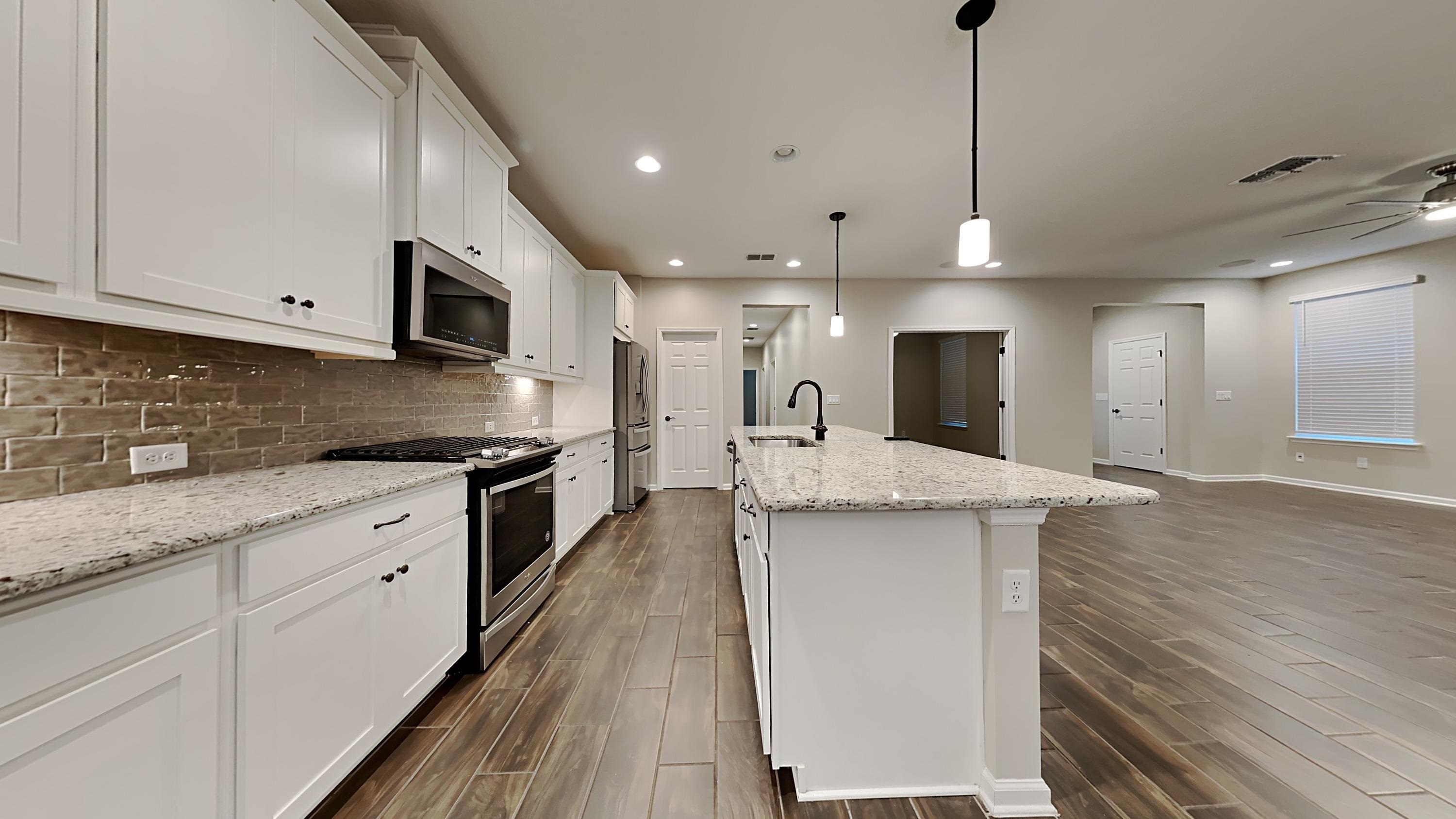 209 Cloverbrook Road St. Johns, FL 32259 - Photo 5 of 13 a large kitchen with stainless steel appliances kitchen island granite countertop a sink a stove and a wooden floors