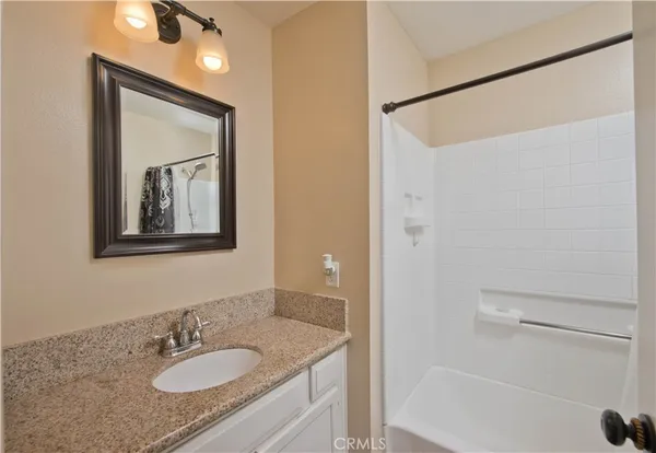 a bathroom with a granite countertop sink mirror vanity and toilet