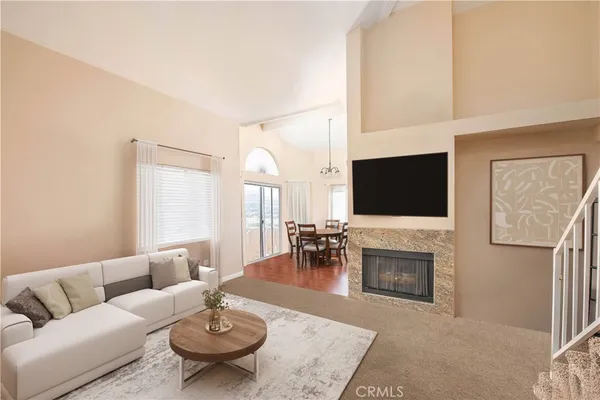 a living room with furniture a flat screen tv and a fireplace