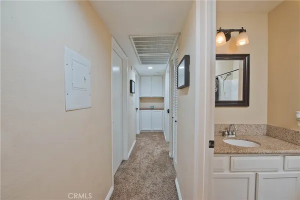 a en suite bathroom with a granite countertop sink and a mirror