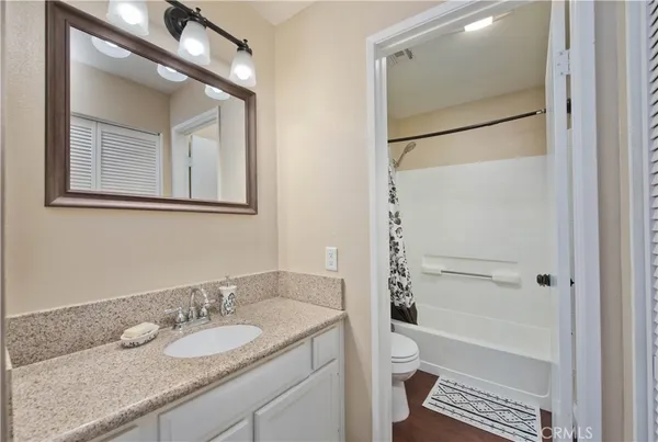 a bathroom with a granite countertop sink toilet and shower