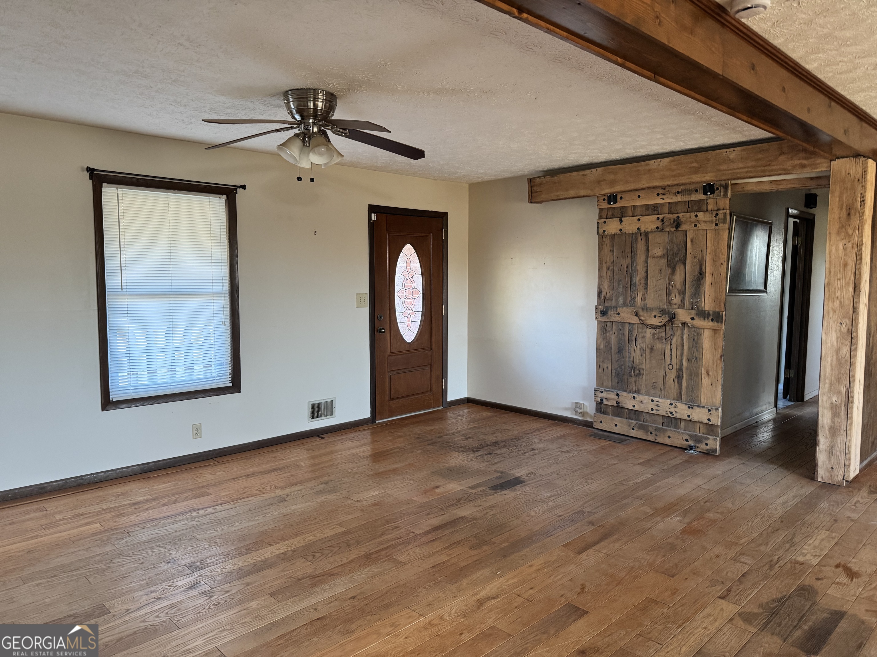 2324 Wilson Road Northwest Conyers, GA 30012 - Photo 4 of 13 an empty room with wooden floor closet and windows