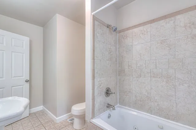 a bath room with a toilet a sink and a bath tub