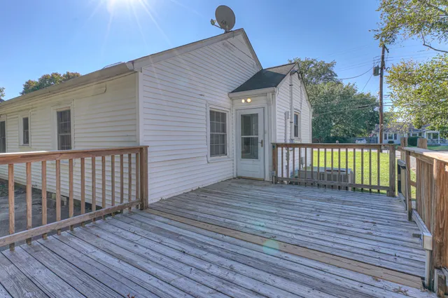 a view of a deck with wooden floor and fence with a floor to ceiling window