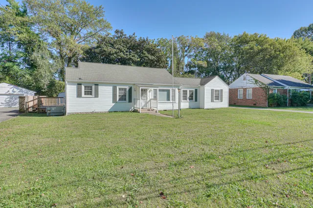 a front view of a house with a garden and trees