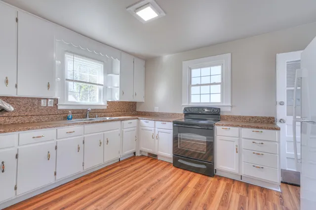 a kitchen with granite countertop white cabinets and white appliances
