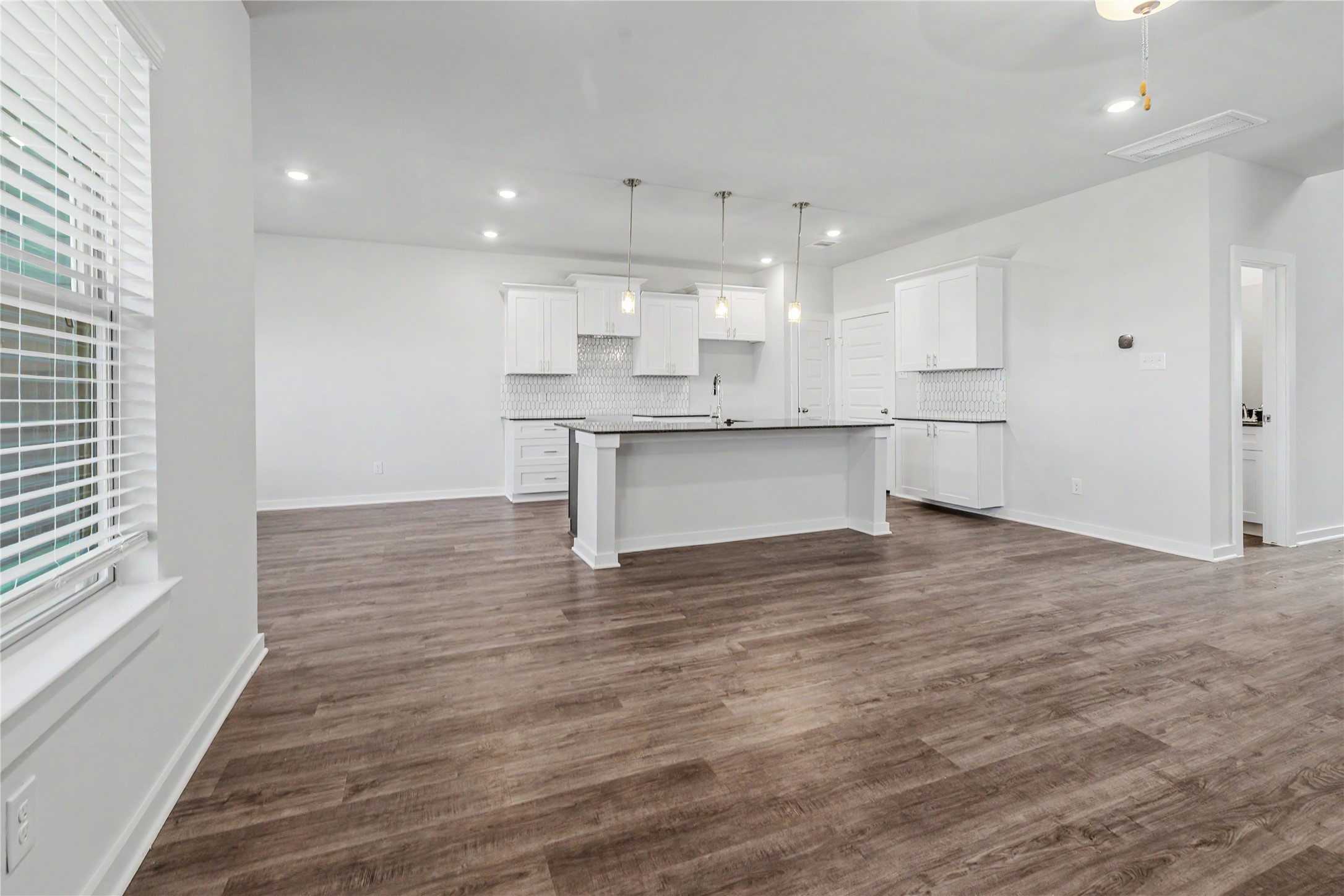 6426 Bolinas Court Rosharon, TX 77583 - Photo 19 of 49 a large white kitchen with kitchen island a sink wooden floor and a refrigerator