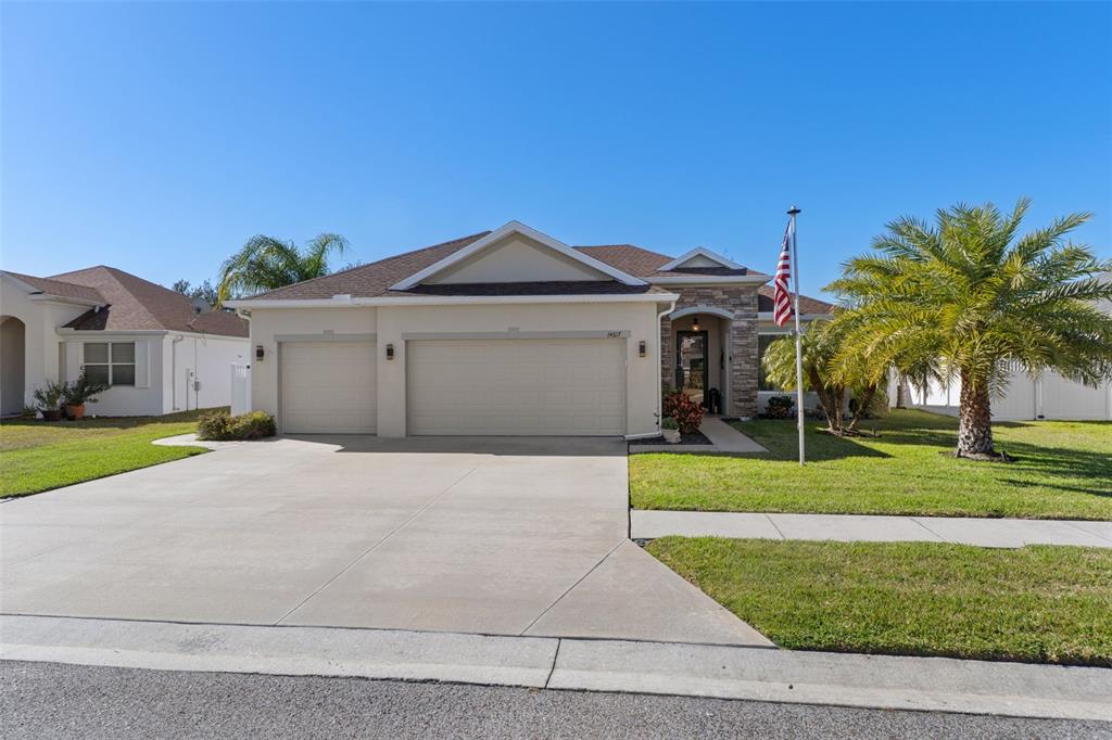 14617 Balloch Drive Hudson, FL 34667 - Photo 63 of 76 a front view of a house with a yard and garage