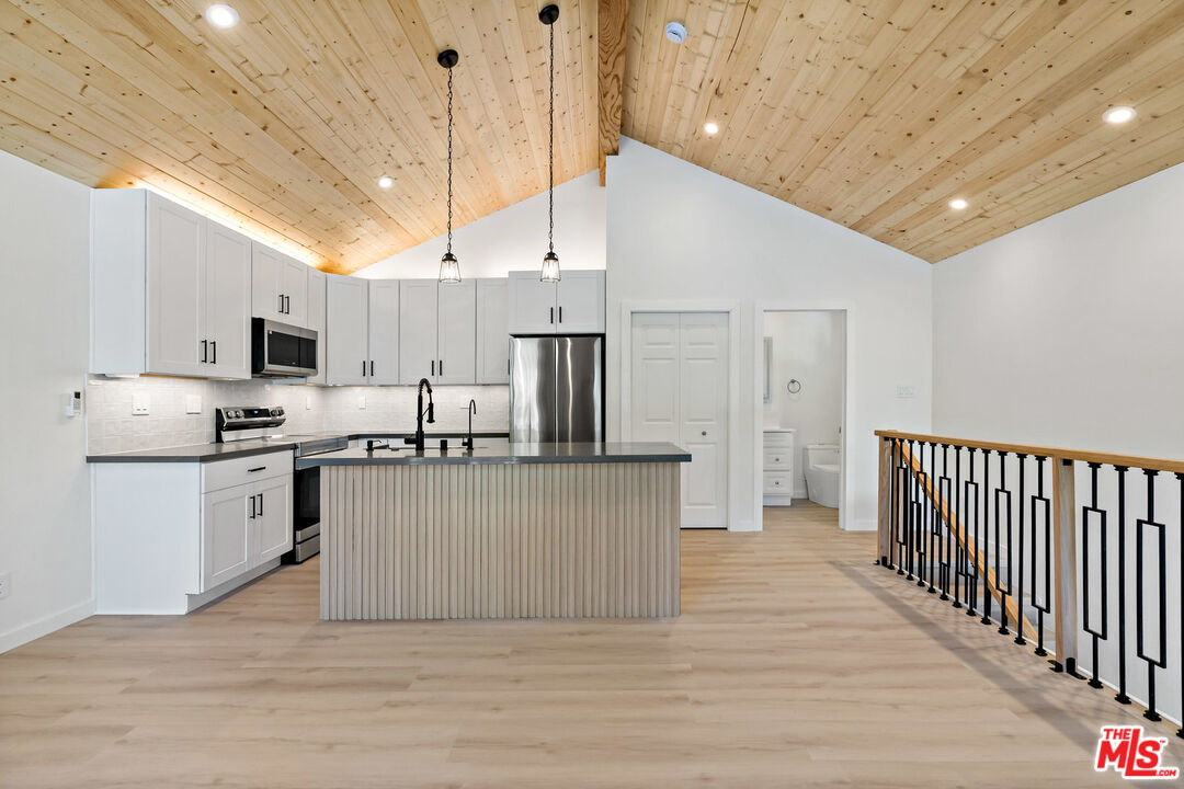 a kitchen with stainless steel appliances a refrigerator and a stove top oven