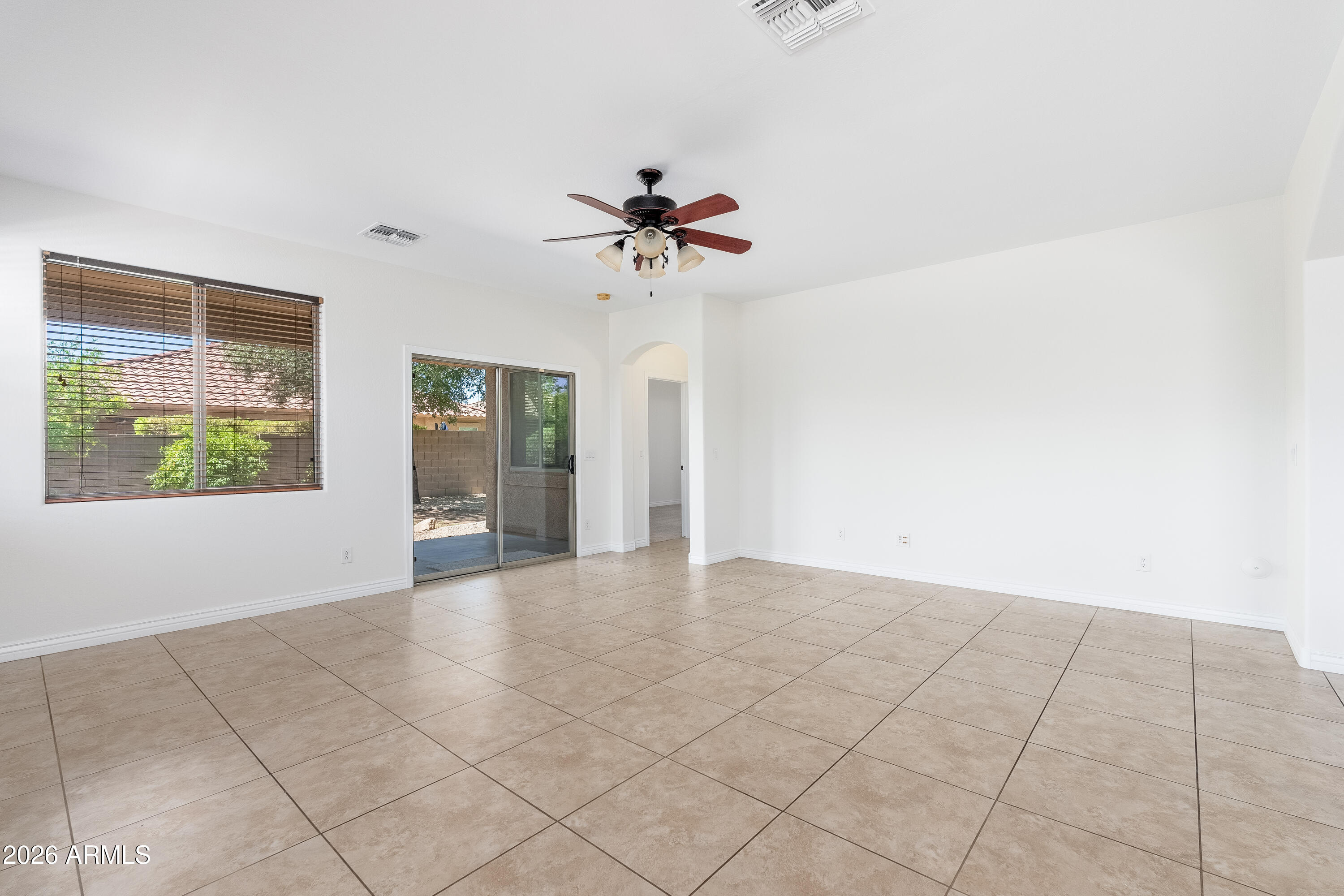 4317 East Folgers Road Phoenix, AZ 85050 - Photo 6 of 40 an empty room with windows and chandelier fan