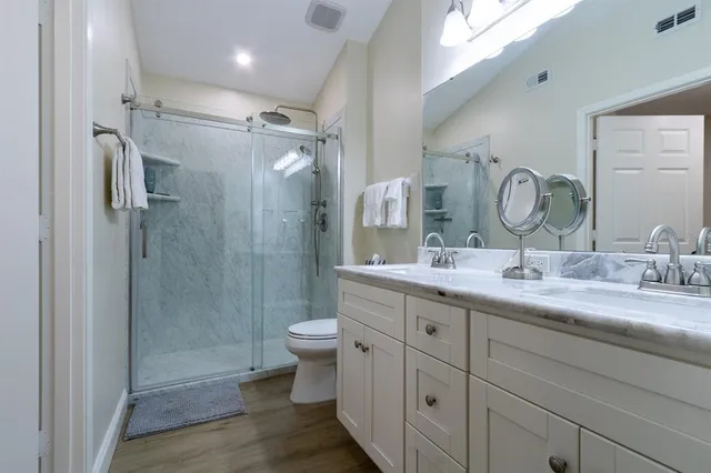 a bathroom with a double vanity sink toilet and shower