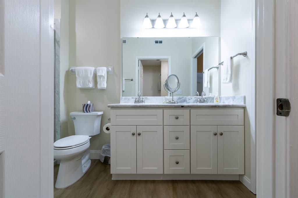 10000 Southwest 52nd Avenue, Unit 60 Gainesville, FL 32608 - Photo 15 of 36 a bathroom with a granite countertop toilet sink and mirror