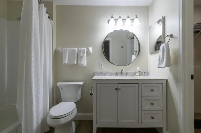 a bathroom with a toilet a sink and mirror
