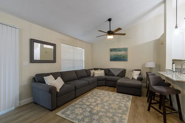 a living room with furniture a ceiling fan and a window