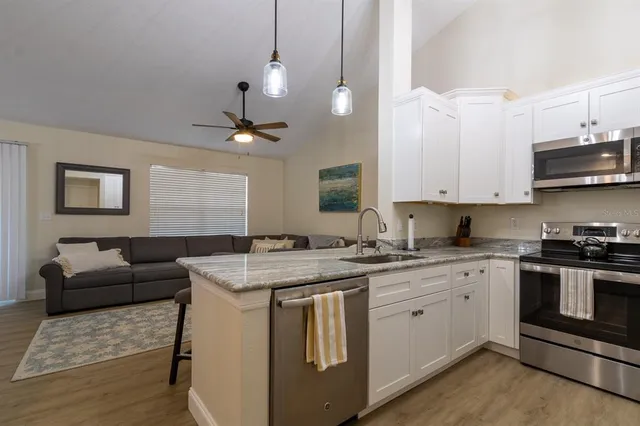 a kitchen with stainless steel appliances granite countertop a stove a sink and a refrigerator