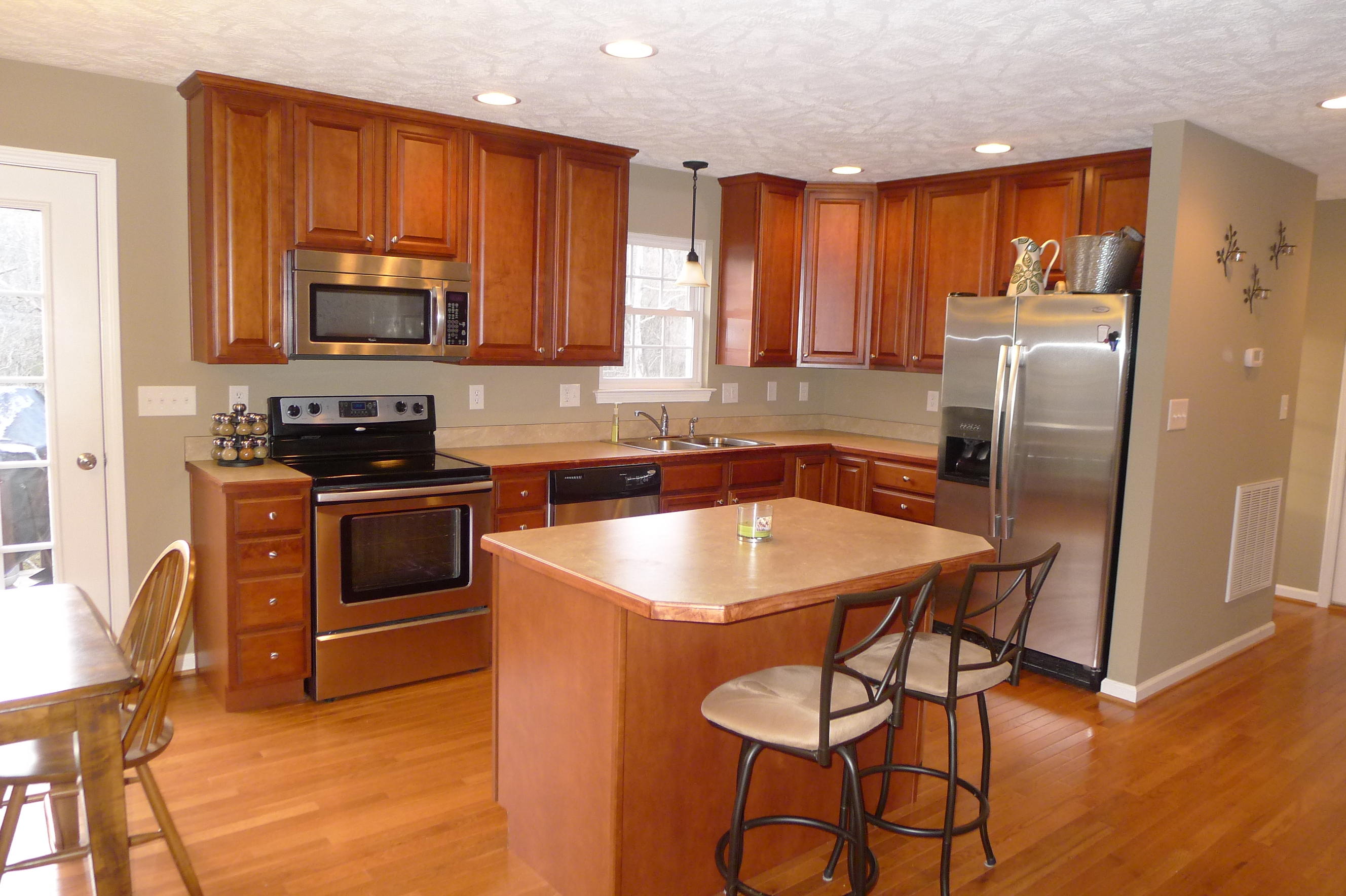 2850 Green Ridge Road Northwest Roanoke, VA 24019 - Photo 7 of 30 a kitchen with stainless steel appliances granite countertop a sink a stove a refrigerator cabinets and a dining table with wooden floor