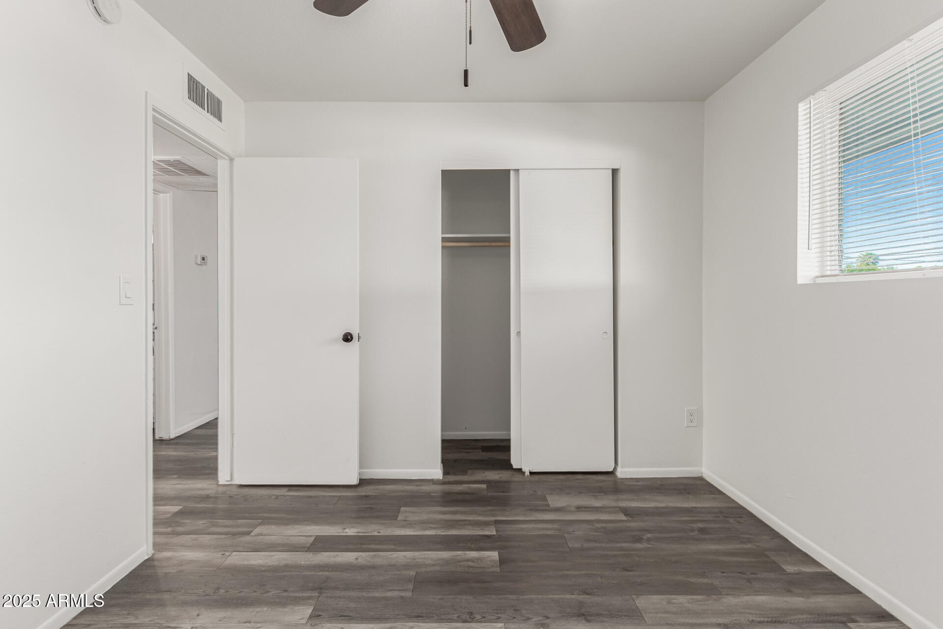 131 North Horne, Unit E Mesa, AZ 85203 - Photo 13 of 26 a view of an empty room with wooden floor and closet