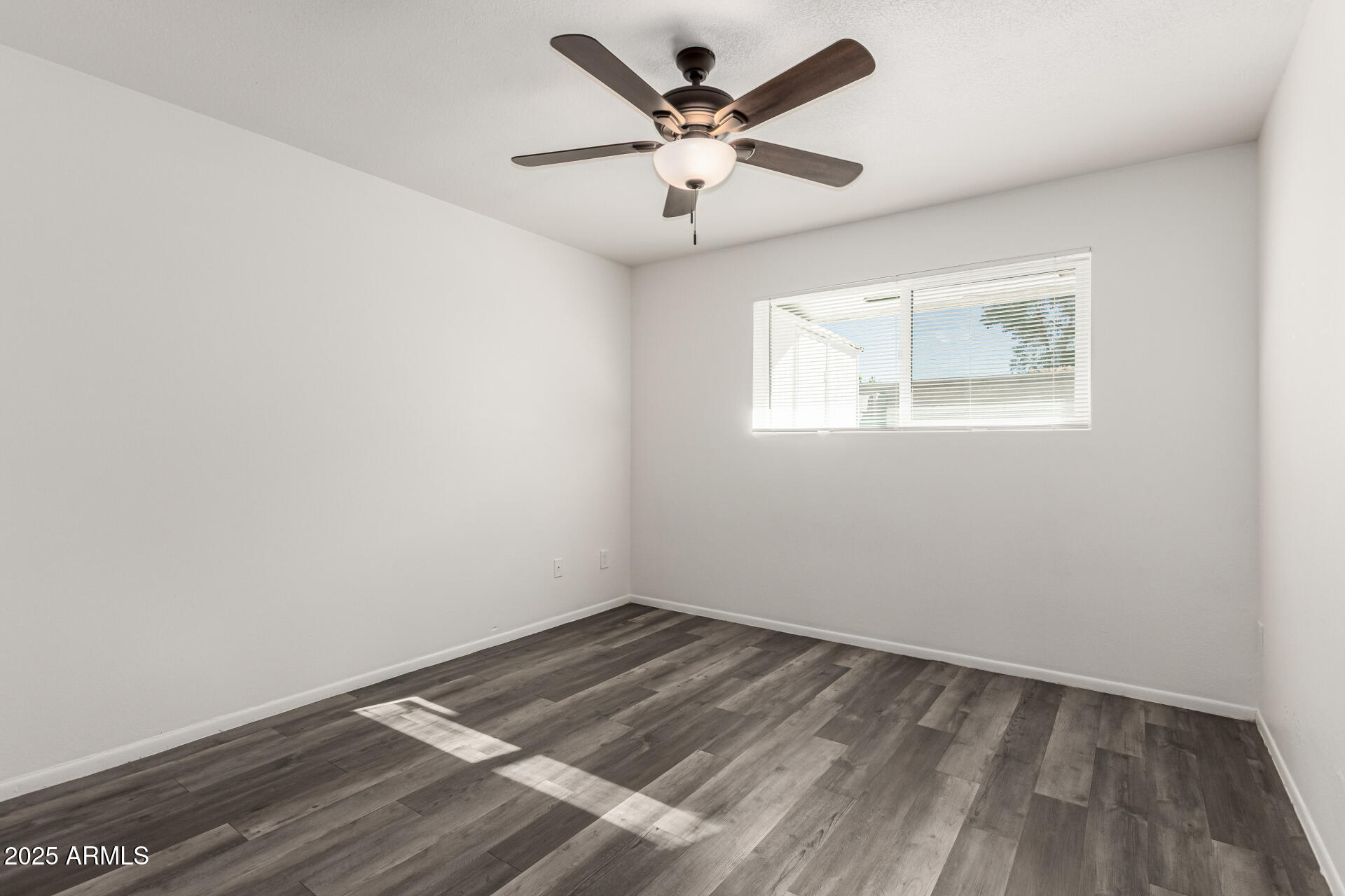131 North Horne, Unit E Mesa, AZ 85203 - Photo 18 of 26 an empty room with a window and a ceiling fan