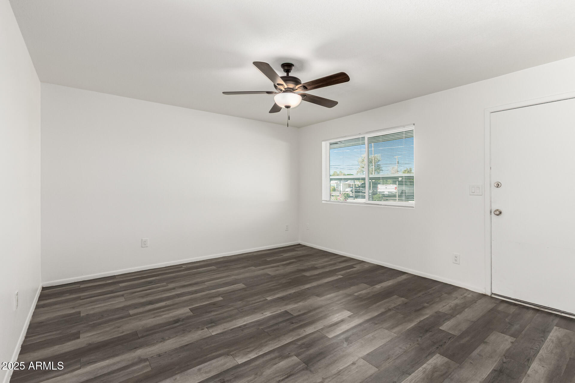 131 North Horne, Unit E Mesa, AZ 85203 - Photo 8 of 26 an empty room with wooden floor ceiling fan and windows