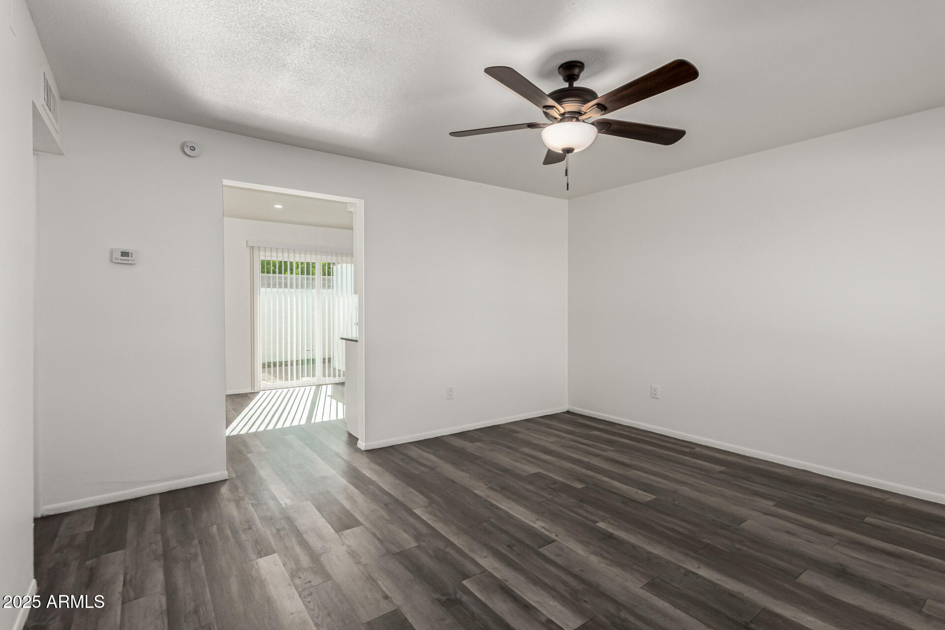 131 North Horne, Unit E Mesa, AZ 85203 - Photo 9 of 26 a view of empty room with wooden floor and ceiling fan