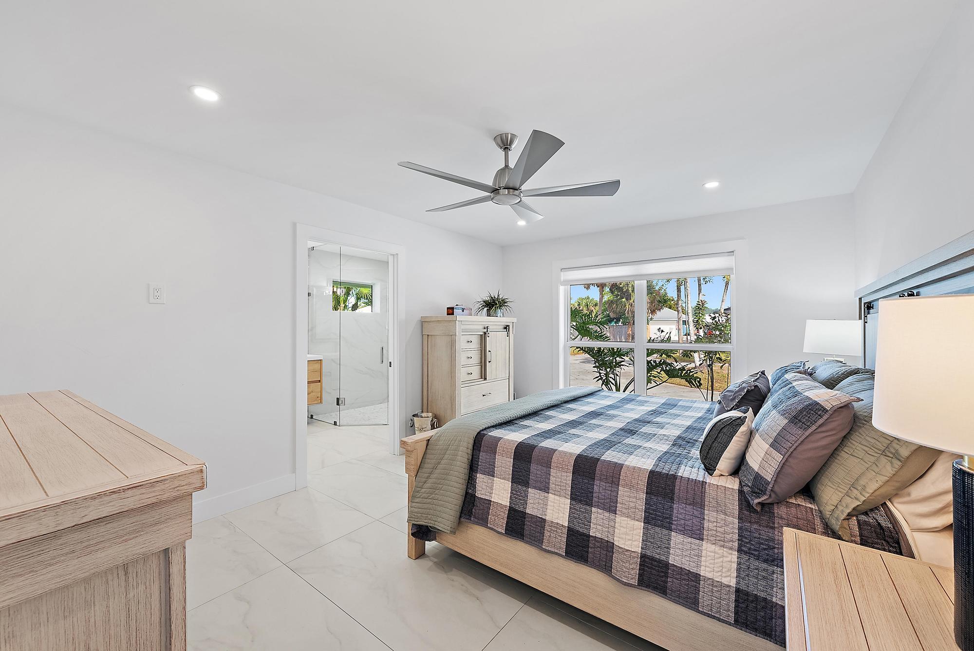 9524 Southeast Cove Point Street Jupiter, FL 33469 - Photo 12 of 35 a bedroom with a bed and a dresser with rug