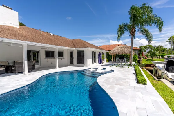a view of a house with swimming pool and sitting area