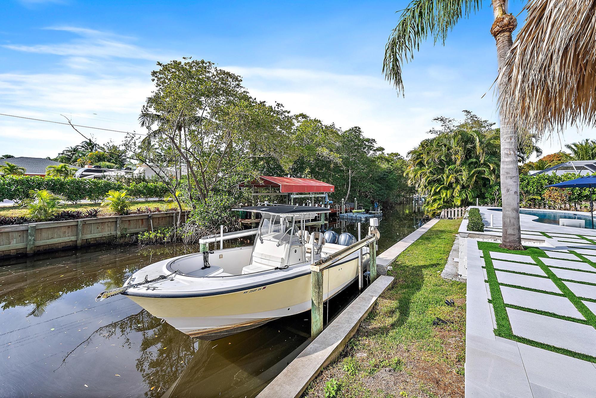 9524 Southeast Cove Point Street Jupiter, FL 33469 - Photo 28 of 35 a view of a lake with couches chairs and a table