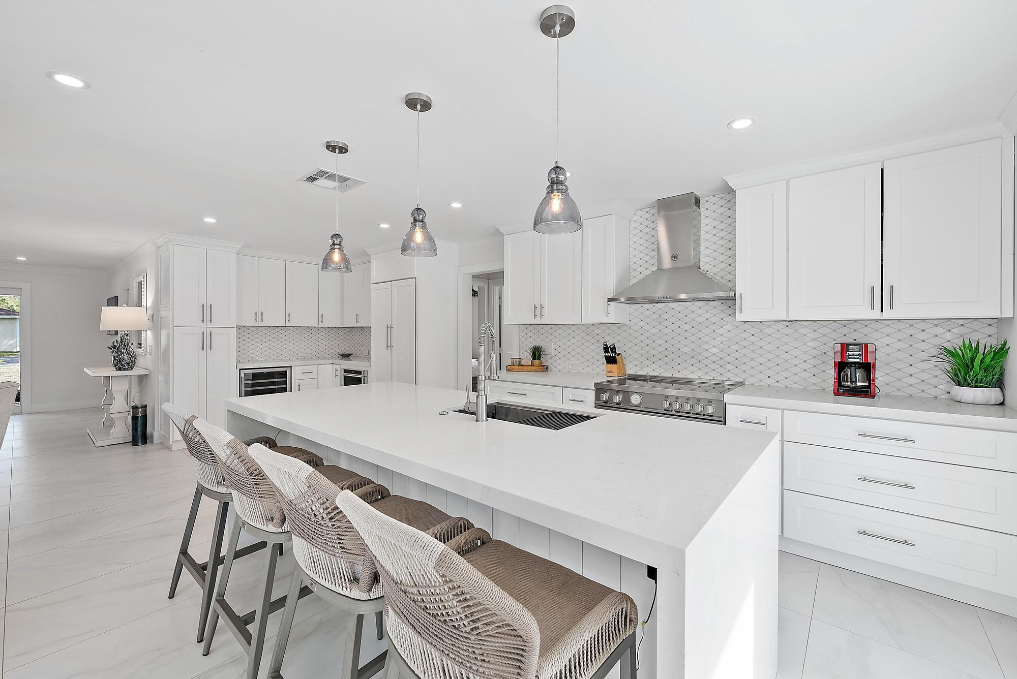 9524 Southeast Cove Point Street Jupiter, FL 33469 - Photo 10 of 35 a kitchen with a sink a stove a refrigerator and white cabinets