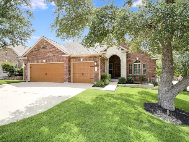a front view of a house with yard and green space