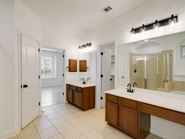a spacious bathroom with a double vanity sink mirror and shower