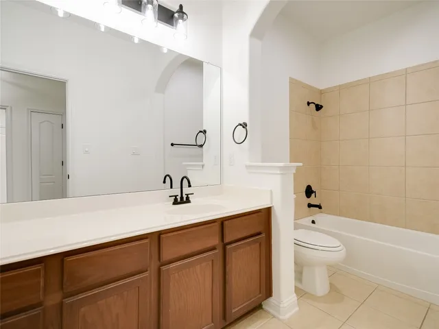 a bathroom with a granite countertop sink a toilet and shower