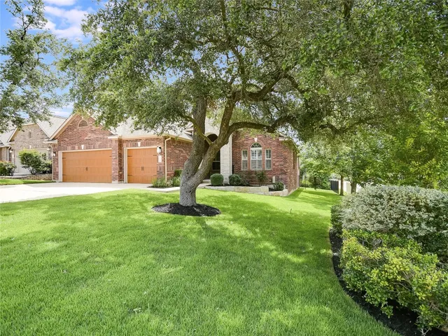 a front view of a house with a garden and trees