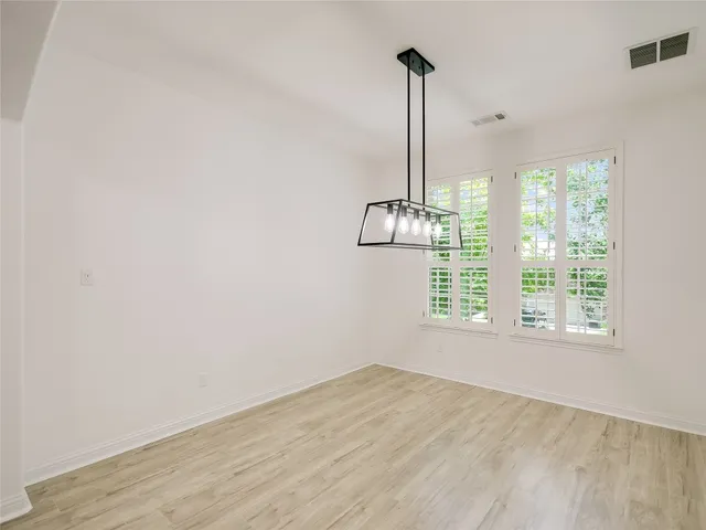 a view of a room with a window wooden floor and a chandelier