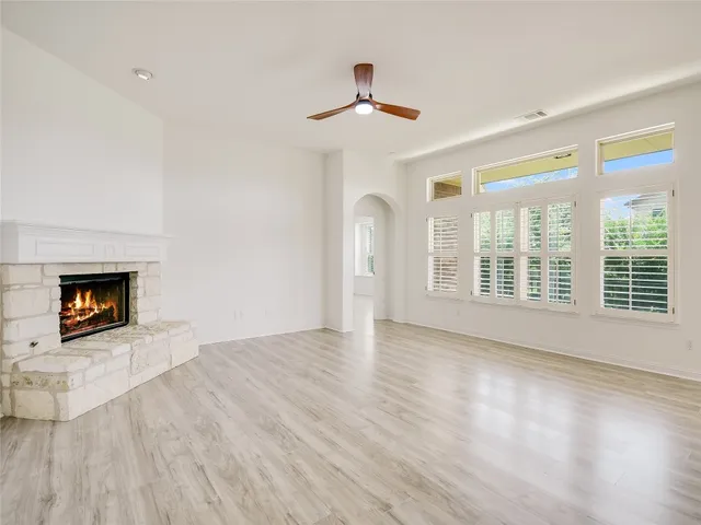 a view of an empty room with a fireplace and a window