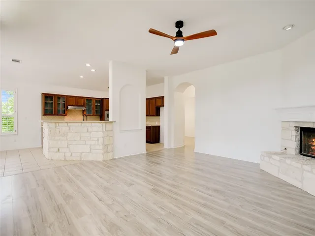 a view of a kitchen with wooden floor and a ceiling fan