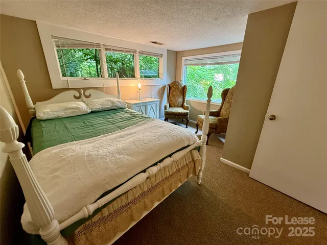 a bed sitting in a bedroom next to a window