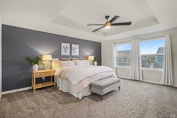 a spacious bedroom with a bed table and window