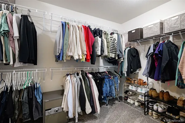 a view of walk in closet with clothes and shoes