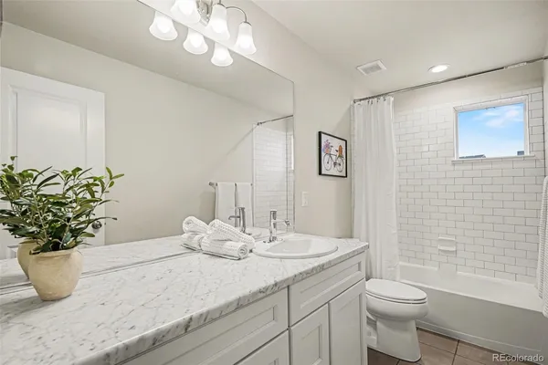a bathroom with a granite countertop sink a toilet and a mirror