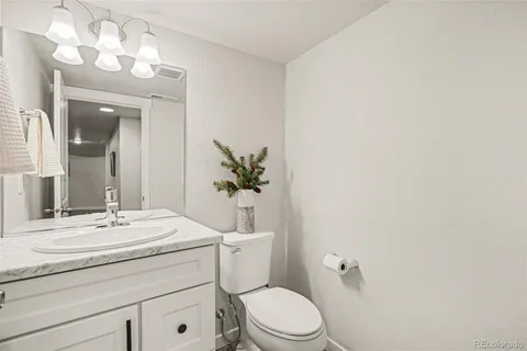 a bathroom with a sink vanity mirror and toilet