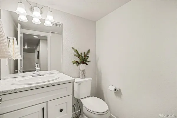 a bathroom with a sink vanity mirror and toilet