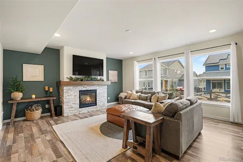 a living room with furniture a flat screen tv and a fireplace