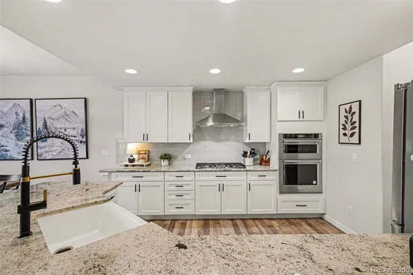 a kitchen with stainless steel appliances granite countertop a stove sink and cabinets