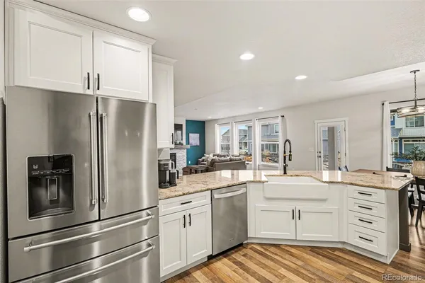 a kitchen with a refrigerator and white cabinets